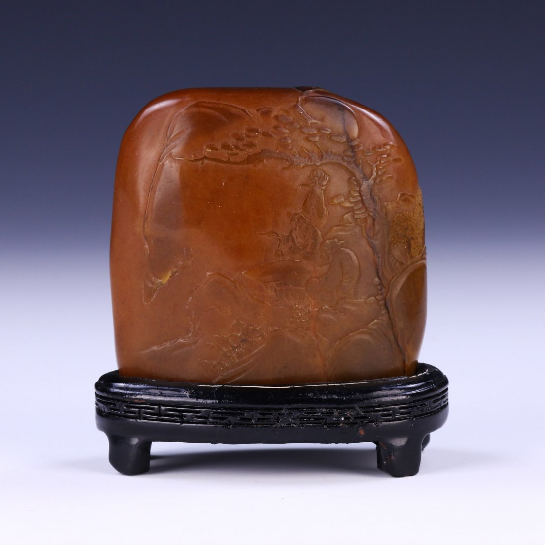 A CHINESE SOAPSTONE CARVED MOUNTAIN: Finely Carved With A High Relief Courtyard Scene, The Stone Of A Rich Honey Tone, Presented On A Custom Wooden Stand; Size: Overall L: 3-3/4" (9.53cm); L: 3-1/2" (8.89cm)