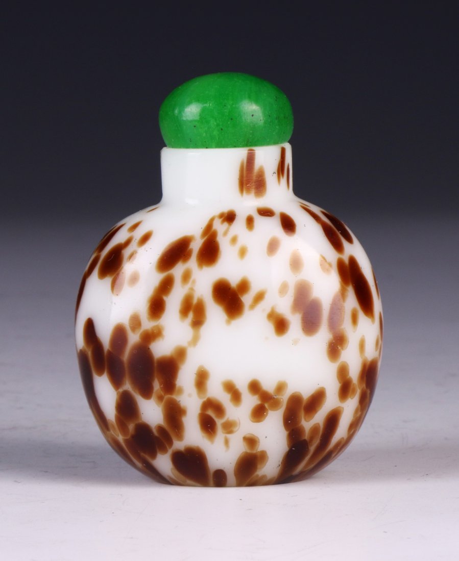 A CHINESE ANTIQUE PEKING GLASS SNUFF BOTTLE: A Chinese Antique Peking Glass Snuff Bottle: Of Globular Form, White Peking Glass Splashed With Red Mottled Tones; Size: H: 2-1/2" (6.35cm)