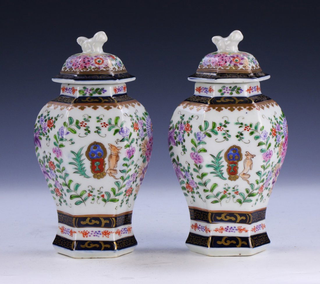 PAIR CHINESE ANTIQUE FAMILLE ROSE LIDDED PORCELAIN: Pair Chinese Antique Famille Rose Lidded Porcelain Vases: Of Hexagonal Baluster Form, Rising To A Domed Lid Topped With An Animal Form Finial, Body Finely Painted With Two Animal Scene Panels Amid Blo