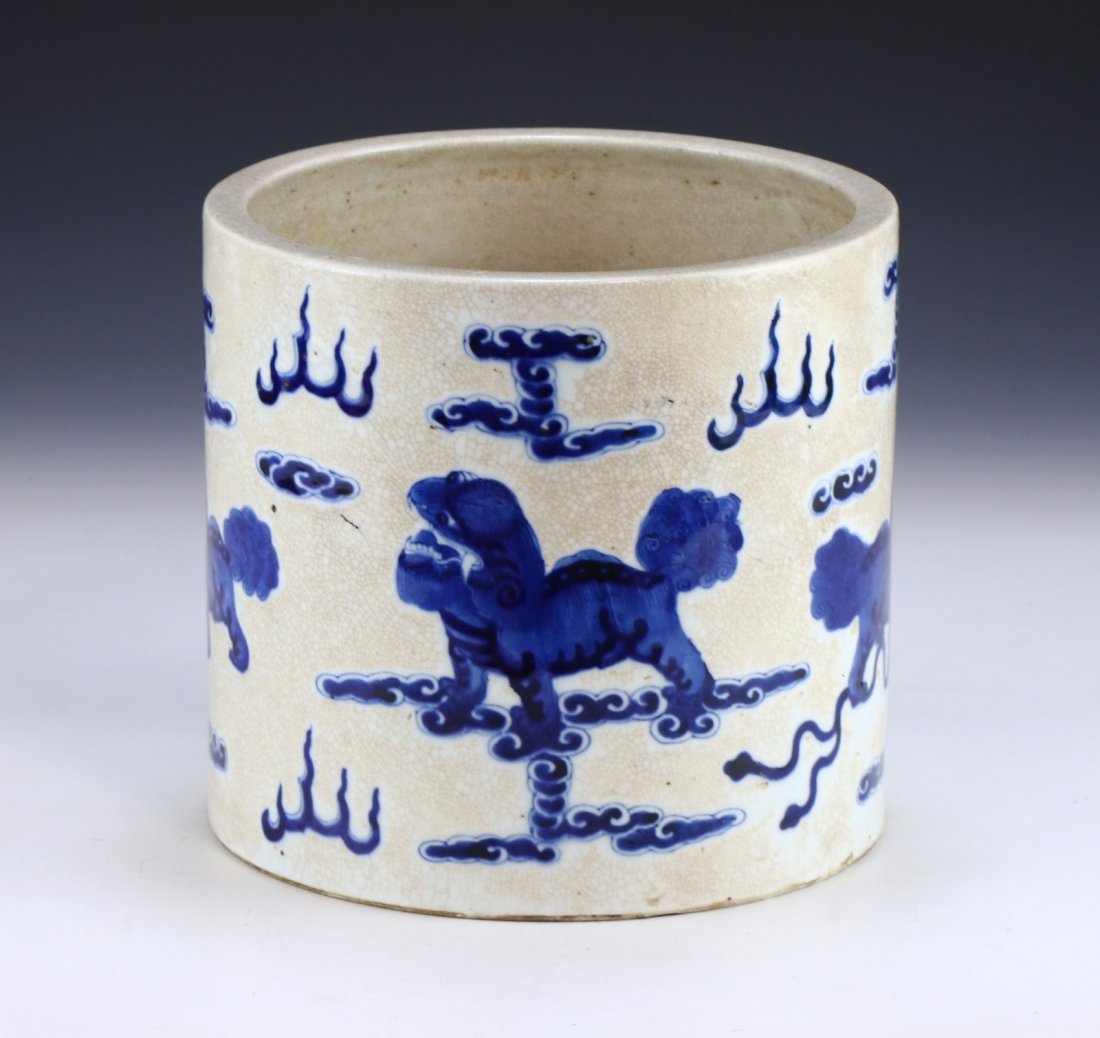 A CHINESE ANTIQUE BLUE & WHITE PORCELAIN BRUSHPOT: A Chinese Antique Blue & White Porcelain Brushpot: Well Potted Of Cylindrical Form, Finely Painted in Cobalt Blue With Large Lion Dog Figures Amid Clouds, Suffused With A Dense Network Of Russet Crack