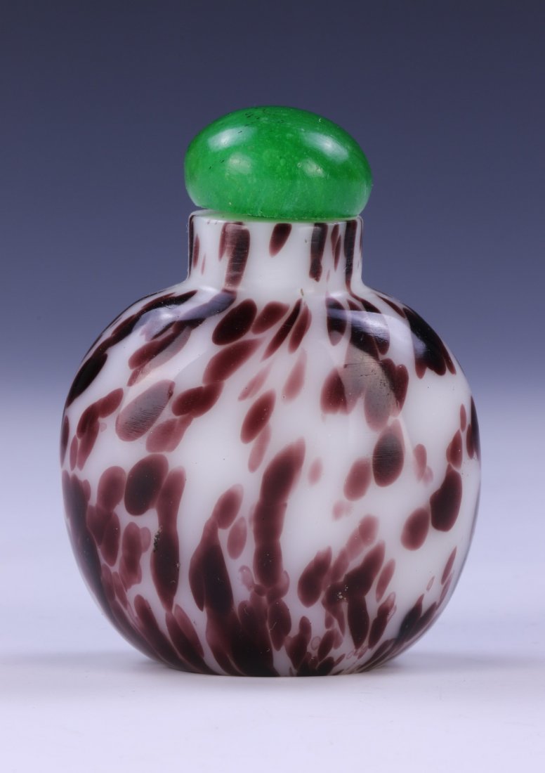 A CHINESE ANTIQUE PEKING GLASS SNUFF BOTTLE: A Chinese Antique Peking Glass Snuff Bottle: Of Globular Form, Cylindrical Neck Rising To A Green Domed Lid, White Glass Mottled With Dark Spots Of Mixed Purple Tones; Size: H: 2-3/4" (6.99cm)