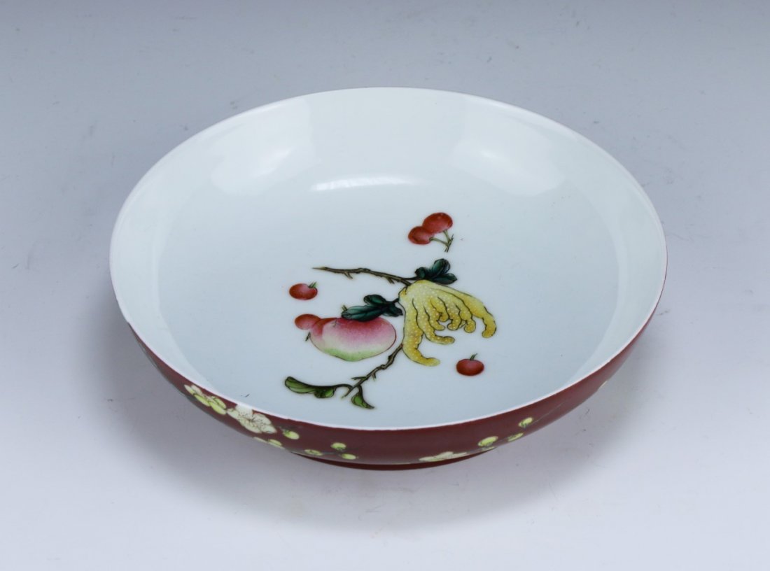 A CHINESE ANTIQUE FAMILLE ROSE PORCELAIN BOWL: A Chinese Antique Famille Rose Porcelain Bowl: The Exterior Finely Painted With Blossoming Branches On An Attractive Crimson Glazed Enamel, The Base With A Four Character Mark in Cobalt Blue Centered