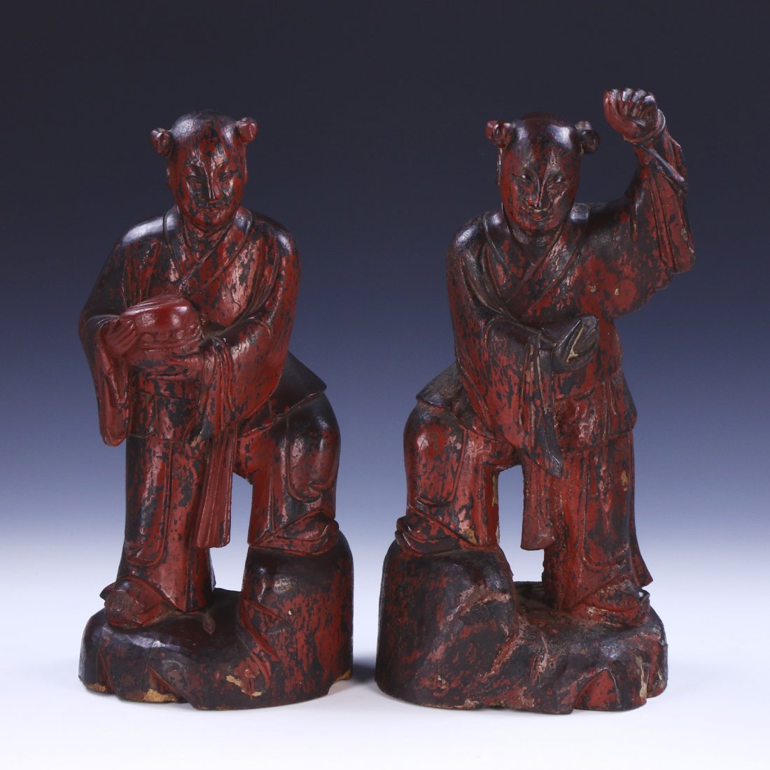 PAIR CHINESE ANTIQUE WOOD CARVED STATUES: Pair Chinese Antique Wood Carved Statues: Finely Carved As Two Figures Dressed in Traditional Robes Standing On Large Boulders, The Wood Of Mixed Dark Brown To Medium Red Tones; Size: H: 14-3/4" (37.4