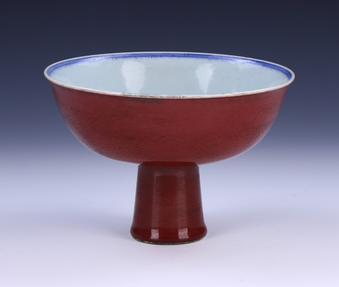 A CHINESE ANTIQUE OX BLOOD PORCELAIN STEM BOWL: A Chinese Antique Ox Blood Porcelain Stem Bowl: Of Rising Sides, interior Of The Base Finely Painted With Blooming Flower Figures Amid Long Stems, Exterior Of The Bowl Evenly Coated in An Ox Blood Gla
