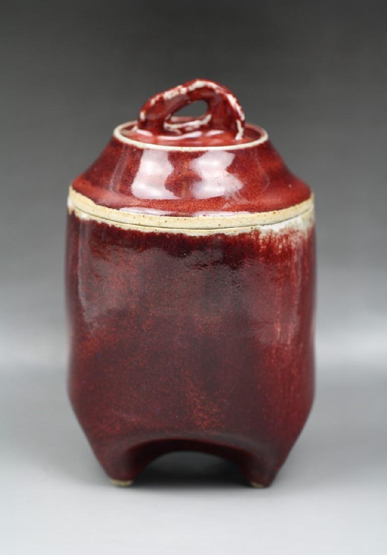 A CHINESE ANTQUE OX-BLOOD PORCELAIN LIDDED JAR: A Chinese Antque Ox-Blood Porcelain Lidded Jar: A Chinese Antique Ox-Blood Porcelain Lidded Jar: Of Cylindrical Form Standing On Four Short Feet With A Slightly Domed Shaped Cover, Applied Overall Wit