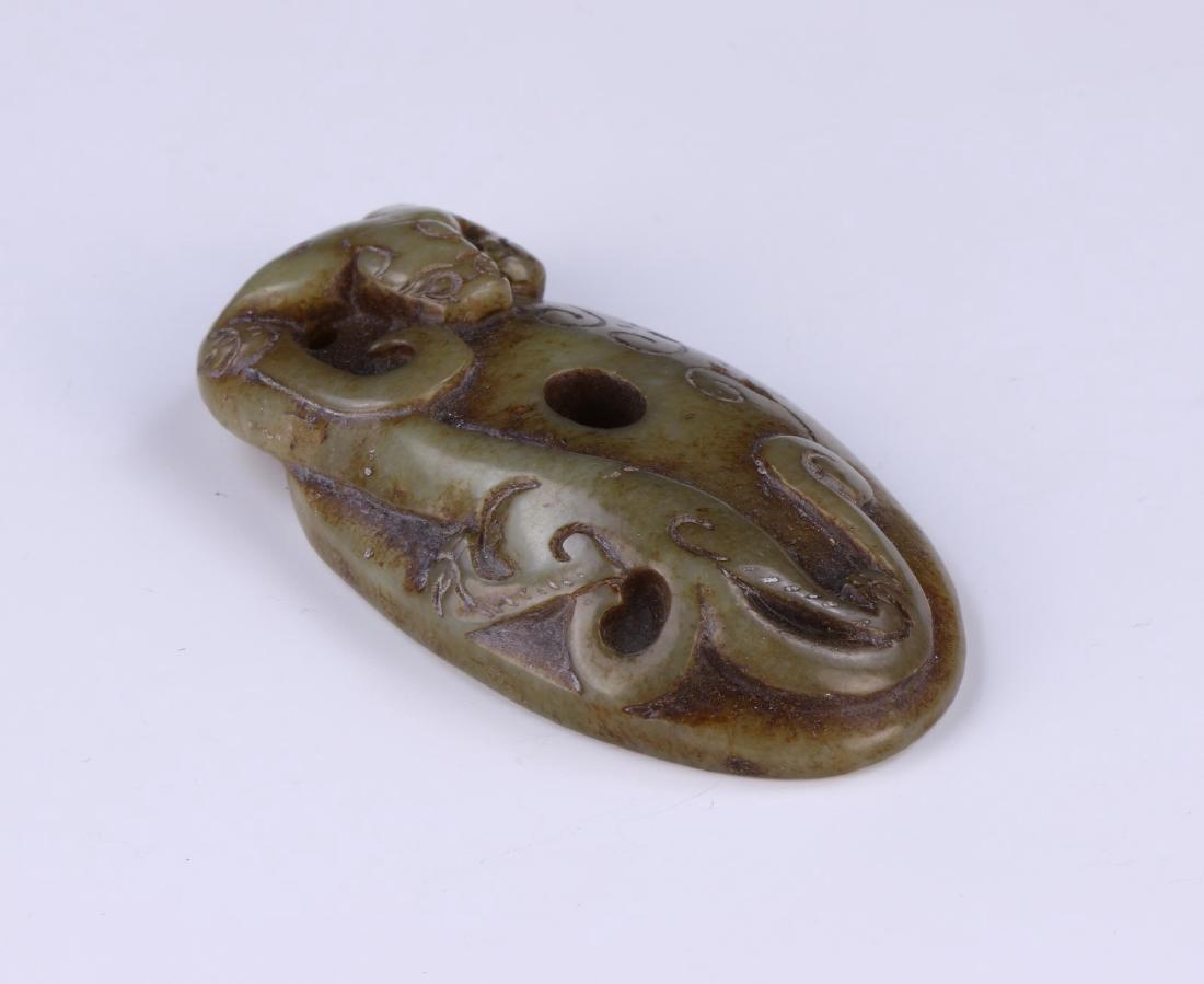 A CHINESE ANTIQUE ARCHAIC JADE CARVING: A Chinese Antique Archaic Jade Carving: Of Ovoid Form, Finely Carved With A Swirling Chi Dragon, The Jade Of Medium Green Tones Mottled With Grey And Brown Spots; Size: H: 2-3/4" (6.99cm)