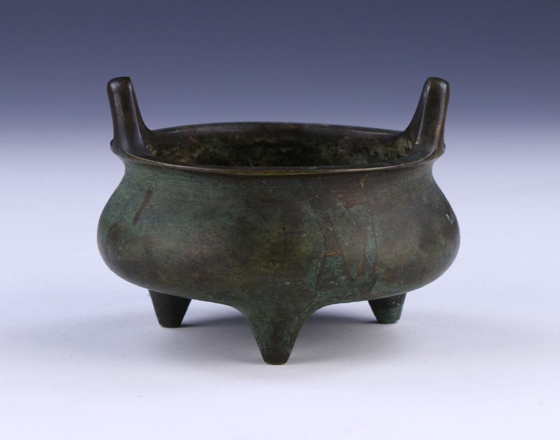 A CHINESE ANTIQUE BRONZE TRI-POD CENSER: A Chinese Antique Bronze Tri-Pod Censer: Rested On Three Low Feet And With Two Straight Handles, With Six Character xuande Mark On The Base, Likely Of Ming Dynasty; Size: H: 3-1/4" (8.26cm)