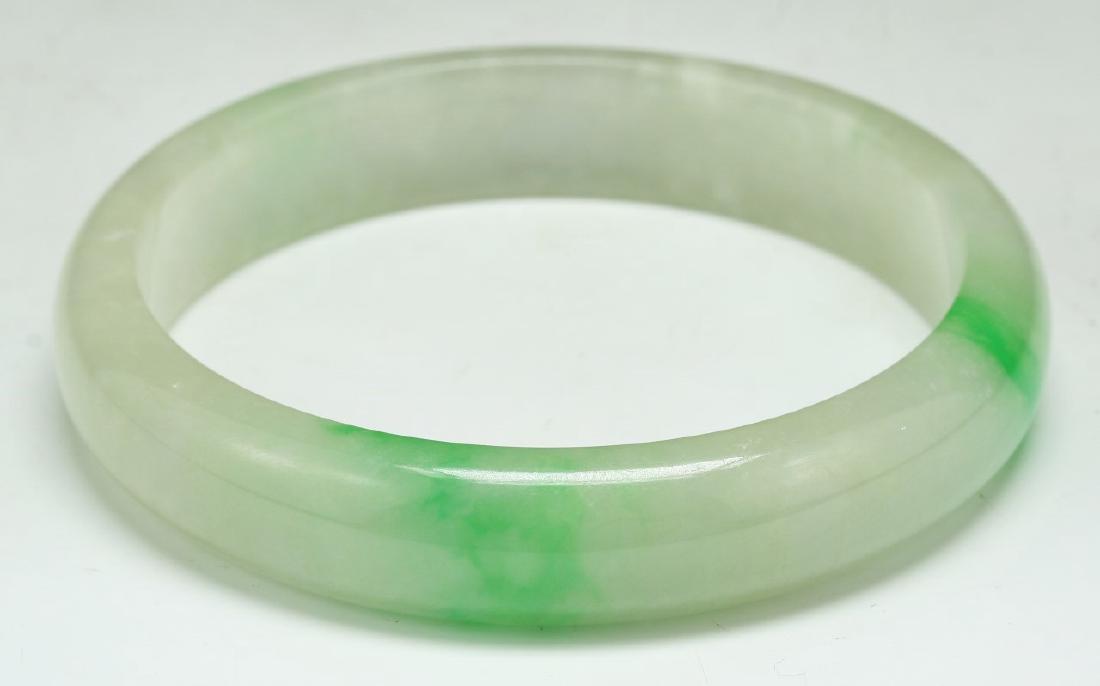A GREEN JADEITE CARVED BANGLE (1 of 3)