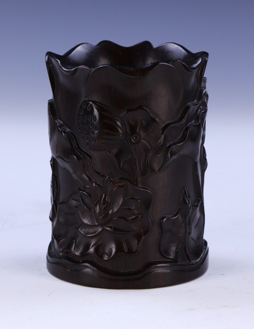 A CHINESE ANTIQUE WOOD CARVED BRUSHPOT: A CHINESE ANTIQUE WOOD CARVED BRUSHPOT: of cylindrical form, finely carved with large blooming flowers amid lily pads; H: 5" (12.7cm)