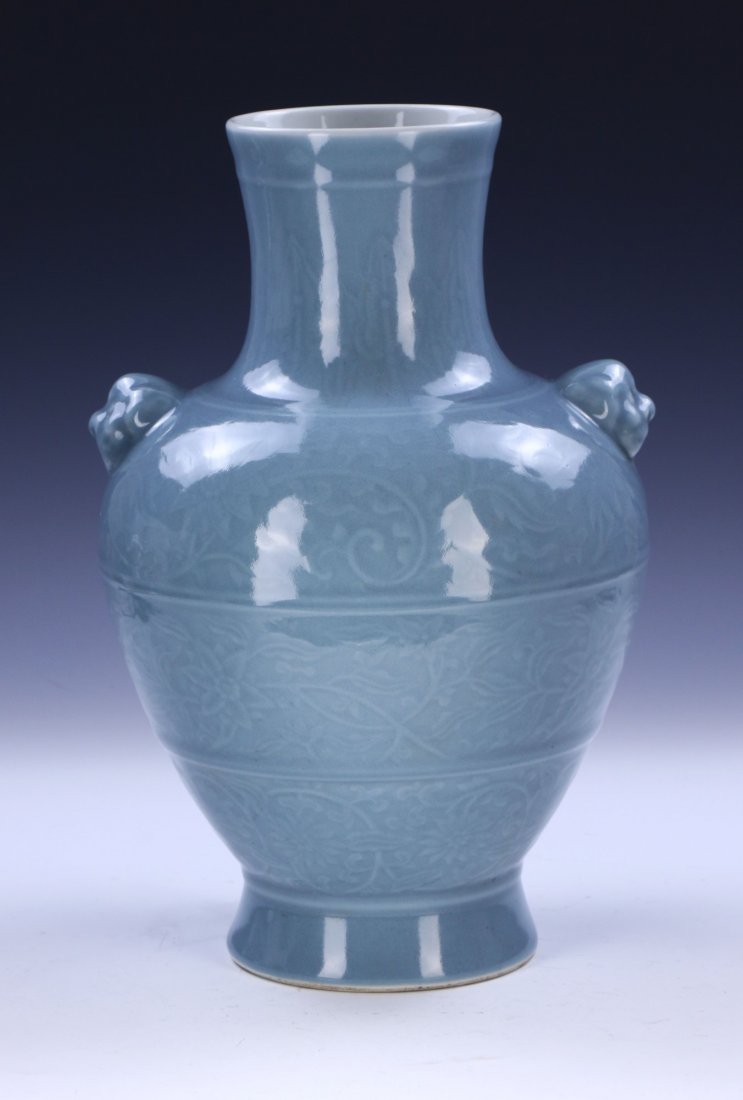 A CHINESE ANTIQUE CELADON GLAZED PORCELAIN VASE: A CHINESE ANTIQUE CELADON GLAZED PORCELAIN VASE: of shouldered form, flanked on each side by menacing mask form handles, ridged body finely painted with blooming flowers amid continuous vines and stem