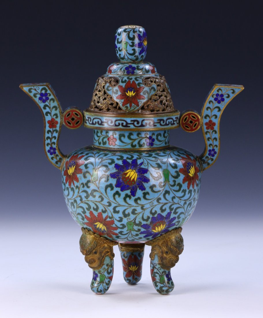 A CHINESE ANTIQUE CLOISONNE LIDDED CENSER: A CHINESE ANTIQUE CLOISONNE LIDDED CENSER: of globular form, the sides with two raised handles molded with round medallions, the domed cover and body decorated with blossoms amid vines on a light blue