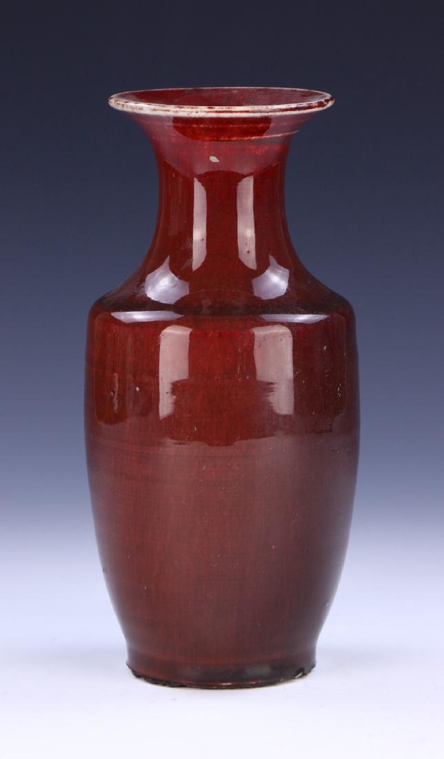 A CHINESE ANTIQUE OX BLOOD GLAZED PORCELAIN VASE: A Chinese Antique Ox Blood Glazed Porcelain Vase: With The High Shoulders Tapering To The Base, Supported By Cylindrical Neck With Splayed Rim, All Thickly Applied With Ox-Blood Glaze Falling White At