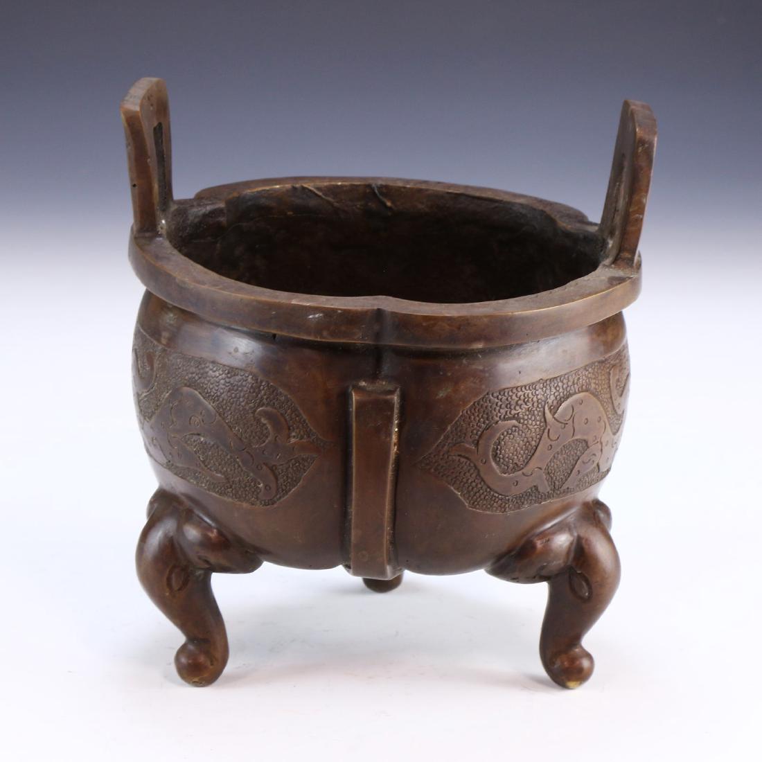 A CHINESE ANTIQUE TRIPOD BRONZE CENSER: A Chinese Antique Tripod Bronze Censer: Of Slight Shouldered Form, High Arching Handles Flanking Each Side Of The Rim, Rising From Three Legs Finely Cast As Elephant Trunks, Dragon Scenes incised into