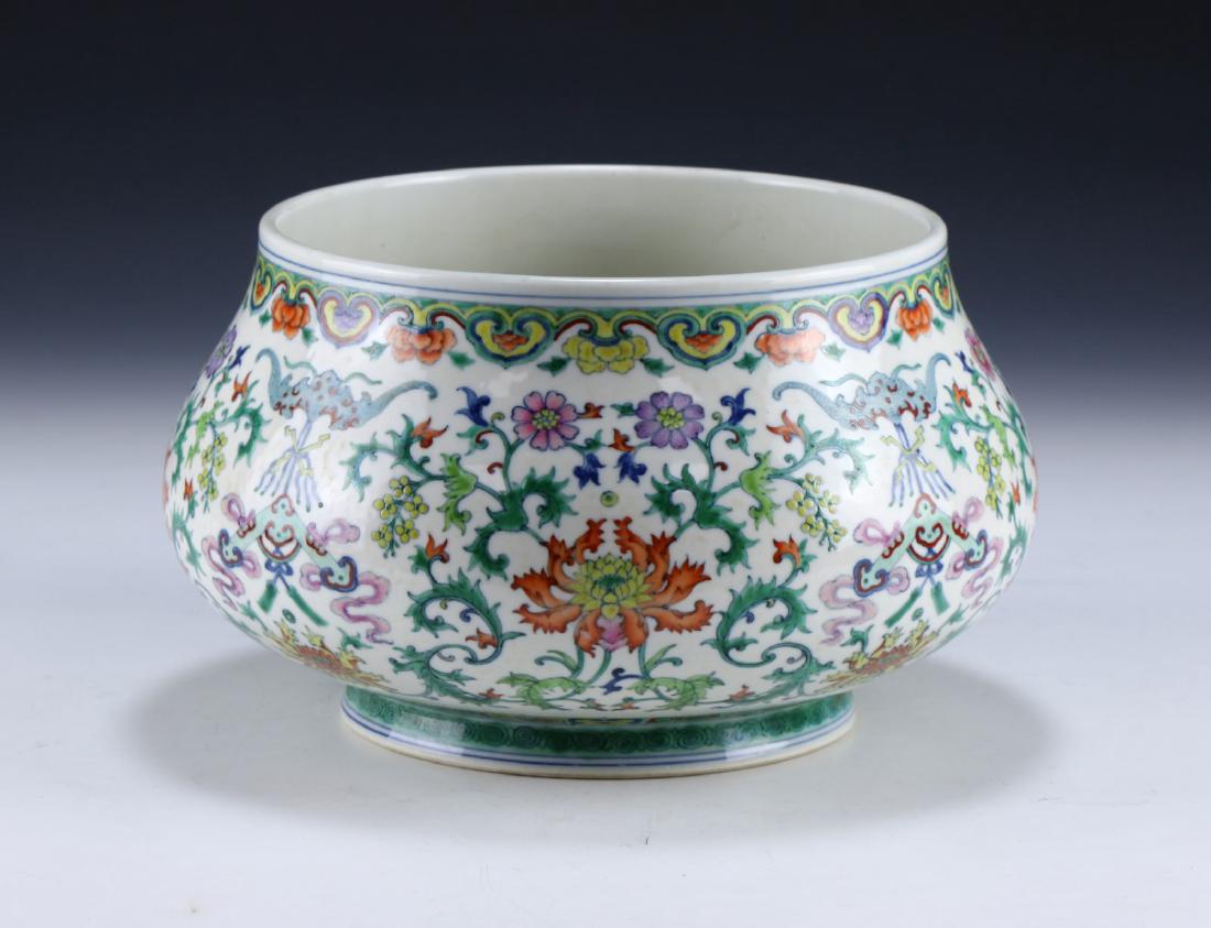 A CHINESE ANTIQUE FAMILLE ROSE PORCELAIN VASE: A Chinese Antique Famille Rose Porcelain Vase: Of Compressed Globular Form, Exterior Finely Painted With Blooming Flowers Amid Continuous Swirling Stems, Six Character Qianlong Mark On The Base in Cob