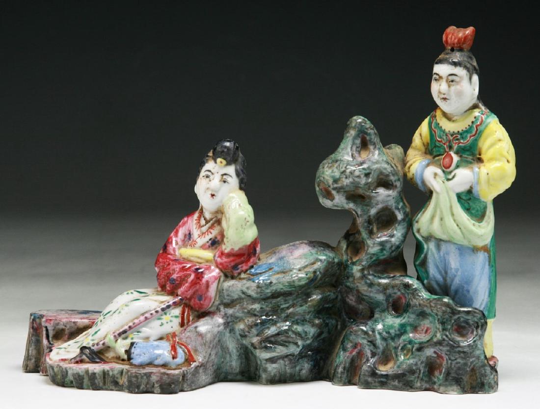 A CHINESE ANTIQUE FAMILLE ROSE PORCELAIN FIGURE GROUP: A Chinese Antique Famille Rose Porcelain Figure Group: Finely Molded As Two Figures Amid Rockery, Of Qing Dynasty; Size: L: 8-1/2" (21.59cm); H: 6" (15.24cm)
