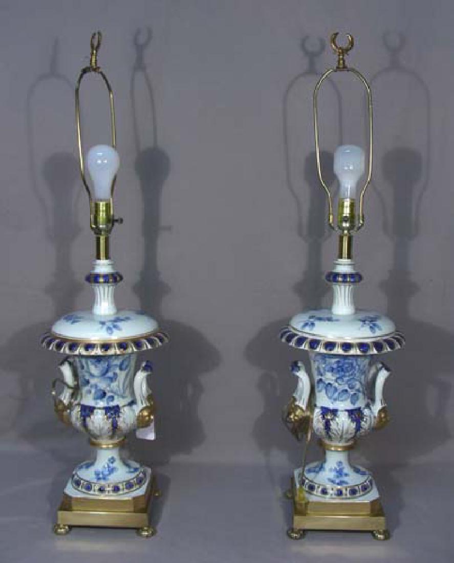 PAIR FREDERICK COOPER BLUE AND WHITE PORCELAIN TABLE: Each lamp with a flow blue pattern and two handles with busts of men. 3' high.