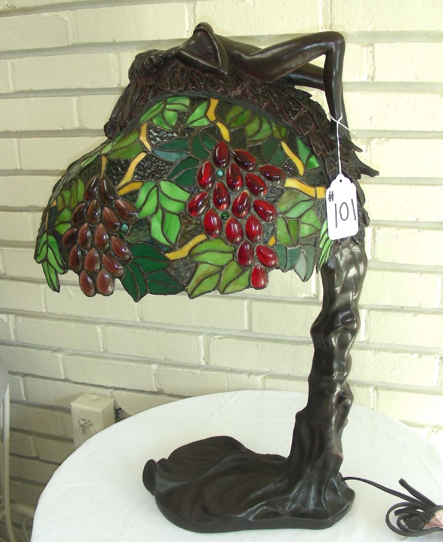 HAND PAINTED AND LEADED GLASS LAMP WITH NUDE: Multi colored leaded glass shade with reclinging nude woman. 25" high.