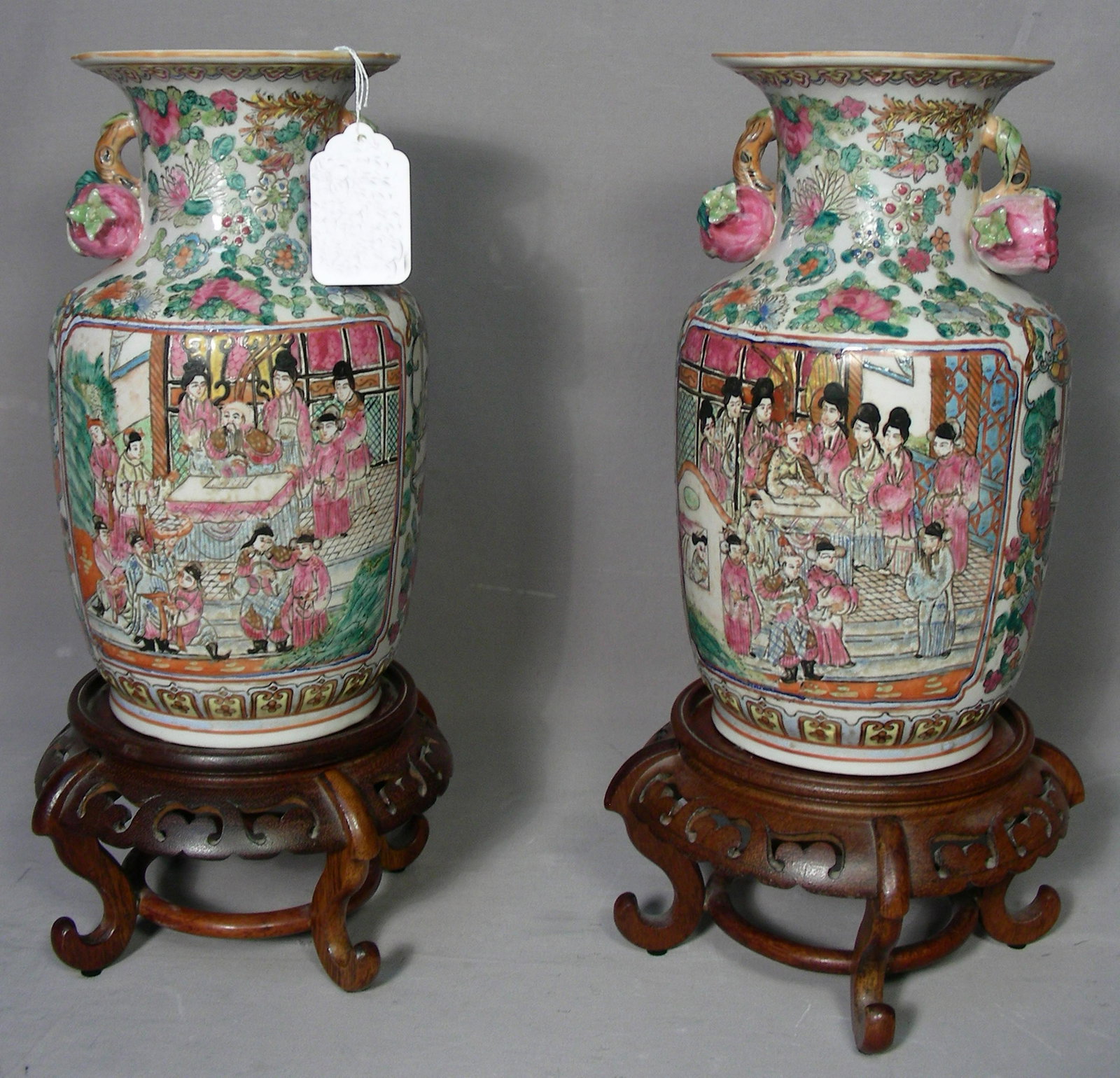 PAIR OLD FINE CHINESE PORCELAIN VASES: Each hand painted Chinese porcelain vase with fruit on handles in high relief. Each vase with rosewood stand. Vases 12 1/2" high (not including stands).