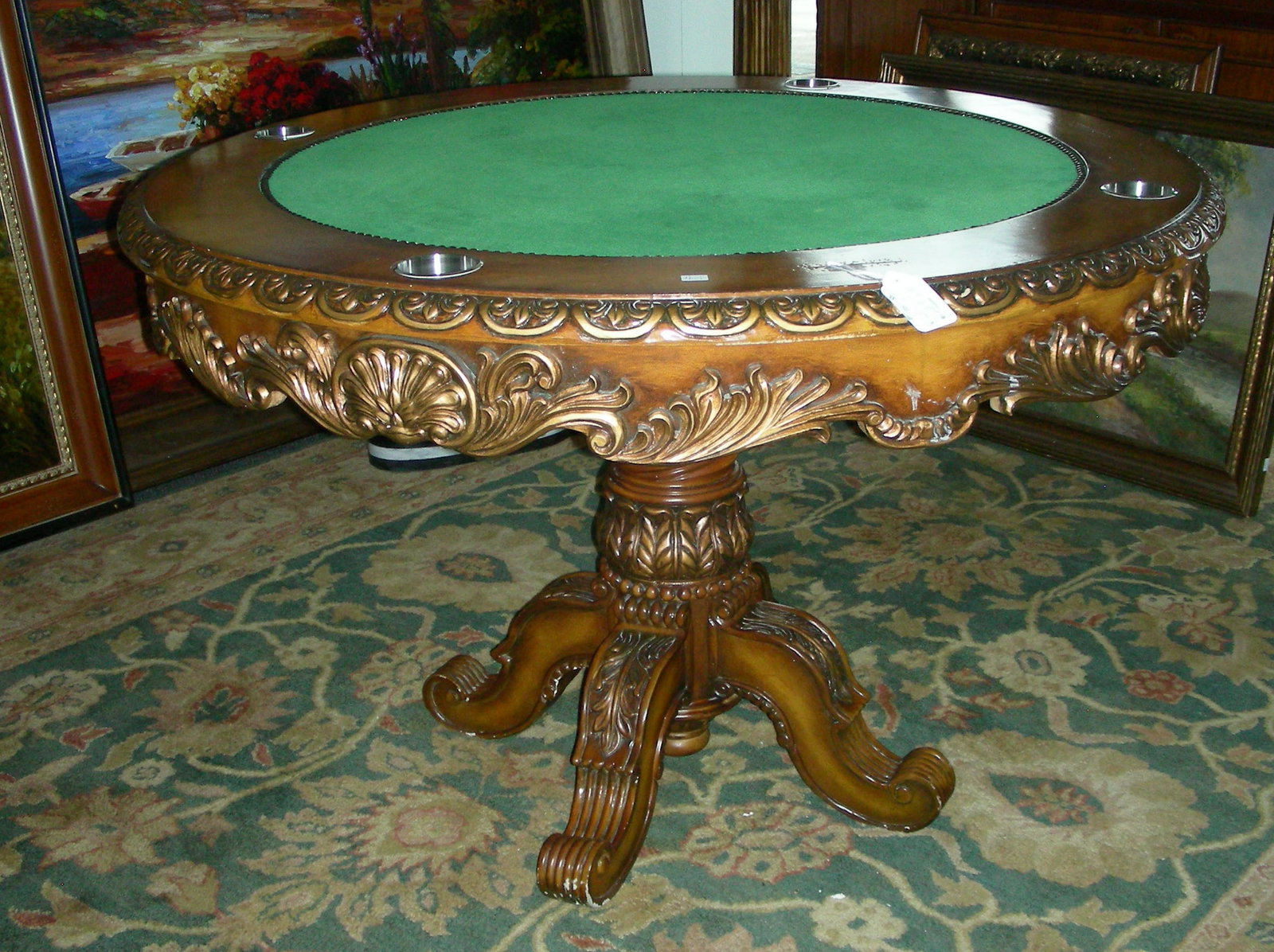 HAND CARVED WOODEN POKER TABLE: A four legged base supports a round table top with green felt center. 31 1/2" high, 4' dia.