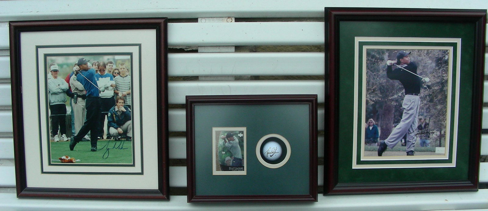 THREE AUTHENTIC HAND SIGNED TIGER WOODS MEMORABILIA: Two hand signed photographs (each with certs on back) and one framed golf ball signed by Tiger . Largest 17" x 14 1/2".
