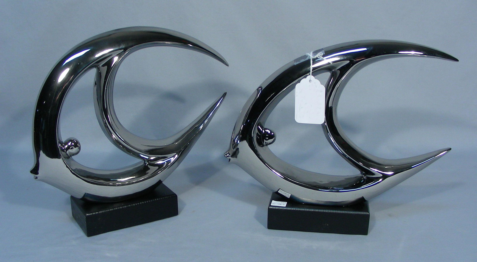 PAIR MODERN CHROME PATINA FISH: Each fish sculpture mounted on black wooden base. Each 12" high, 12 1/2" wide.