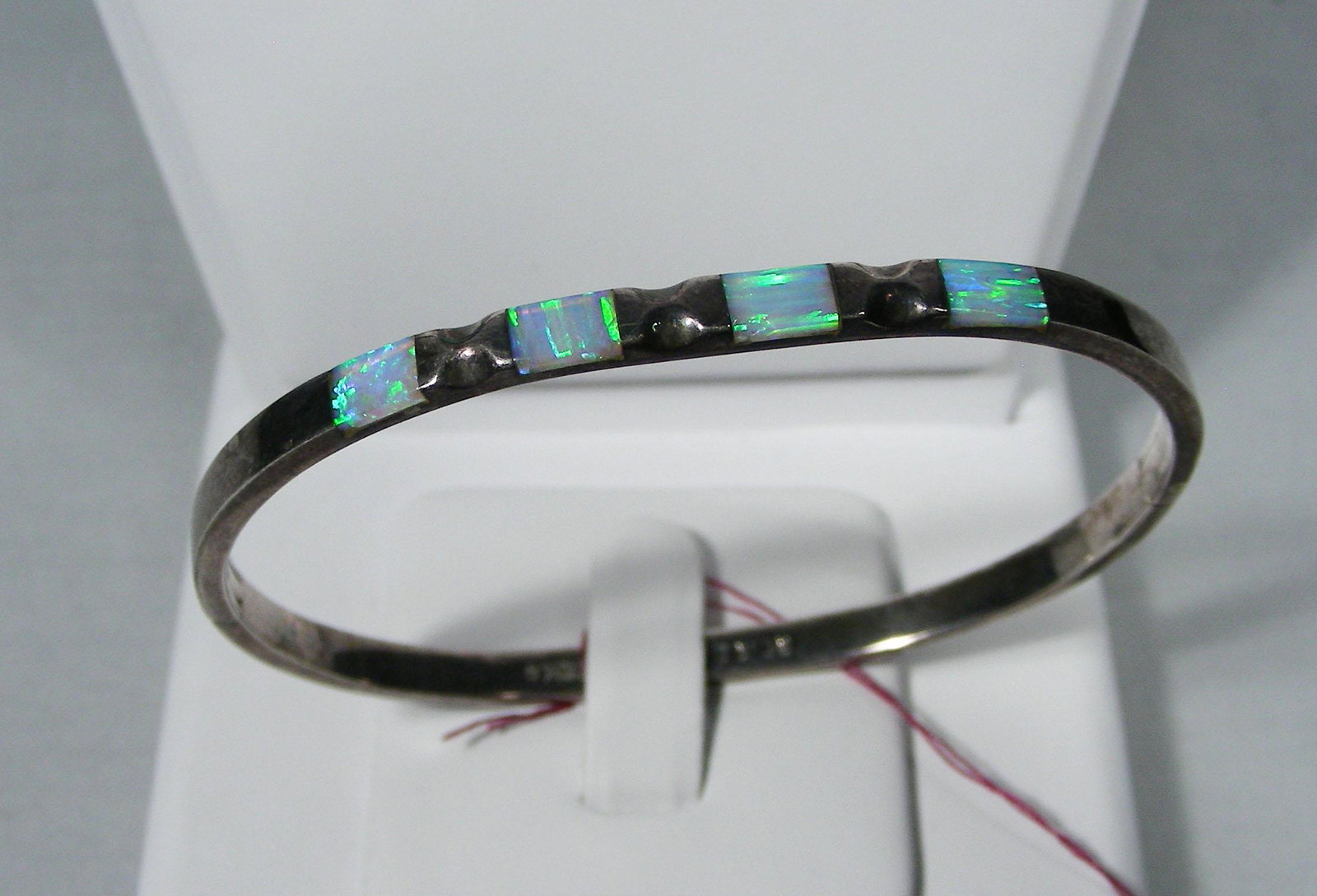 VINTAGE STERLING SILVER AND OPAL BANGLE BRACELET: A highly polished bracelet set with four fine opal. Marked "Mexico 925".
