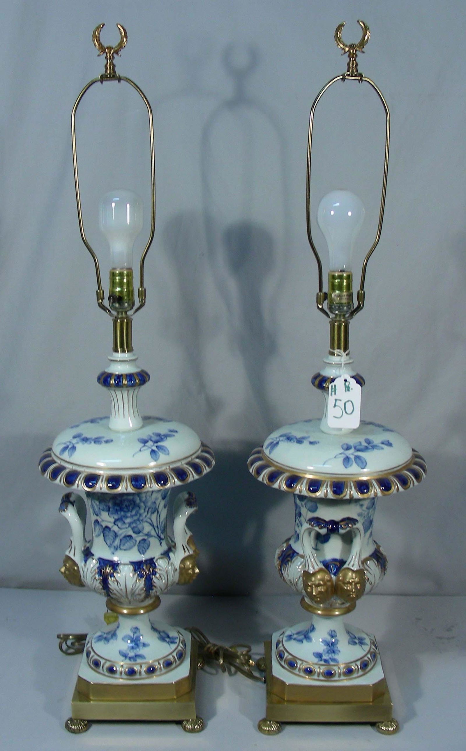 PAIR DESIGNER FREDERICK COOPER PORCELAIN TABLE LAMPS: Blue, white and gold lamps with faces on handles. Heavy brass bases. 38" high. Original Frederick Cooper, Chicago sticker.
