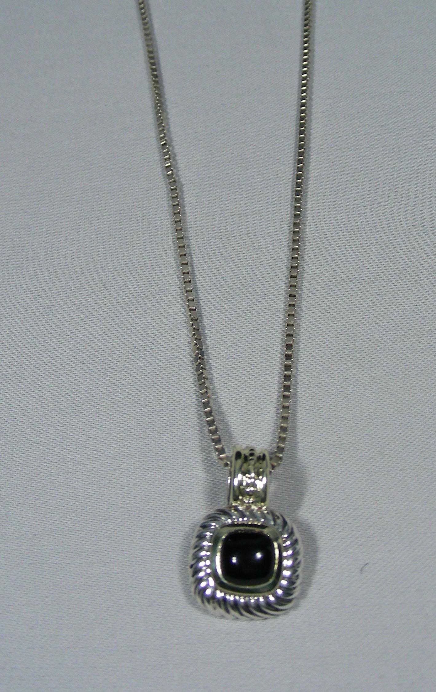 DESIGNER DAVID YURMAN STERLING, 14K Y.G. & ONYX: A sterling silver chain supports a David Yurman sterling silver & yellow gold sterling pendant set with a center cabochon onyx. Signed on back.