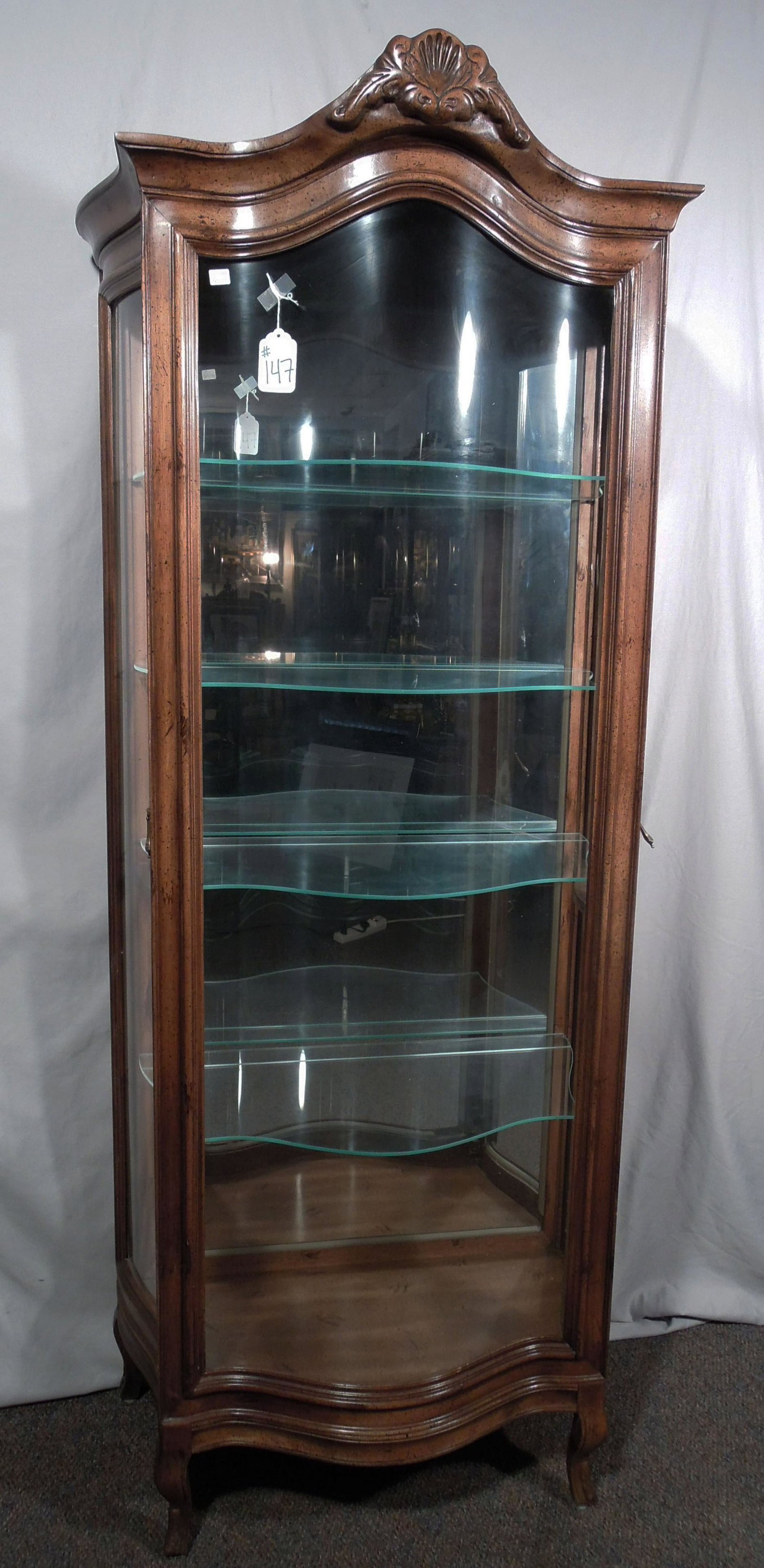 HAND CARVED BOW FRONT CURIO CABINET: Mirrored back. Doors open from sides. Electrified. 73" high, 25" wide, 14" deep.