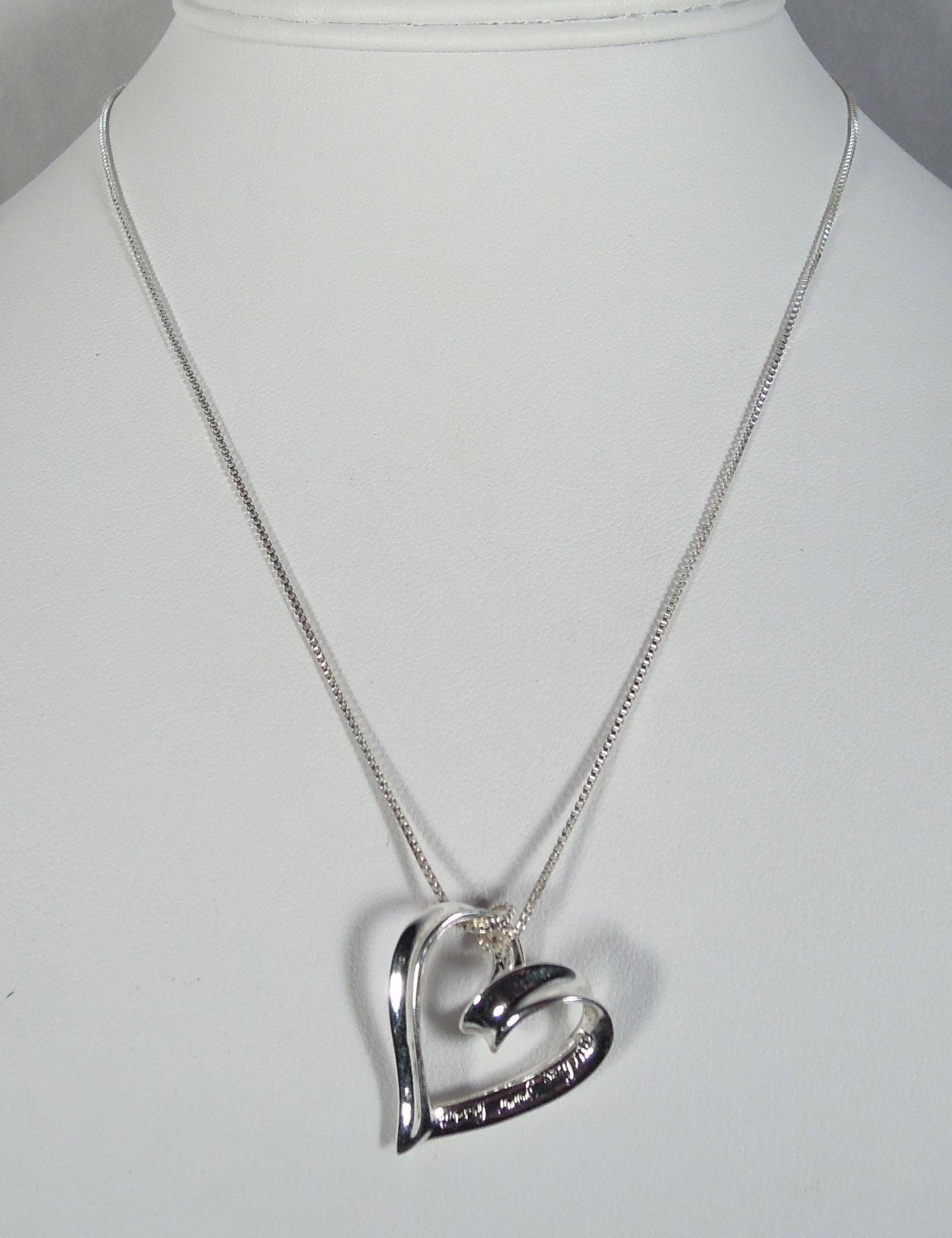 LADIES STERLING SILVER HEART NECKLACE: A delicate sterling chain supports a heart which is engraved "A True Friend Reaches for your Hand that Touches your Heart".