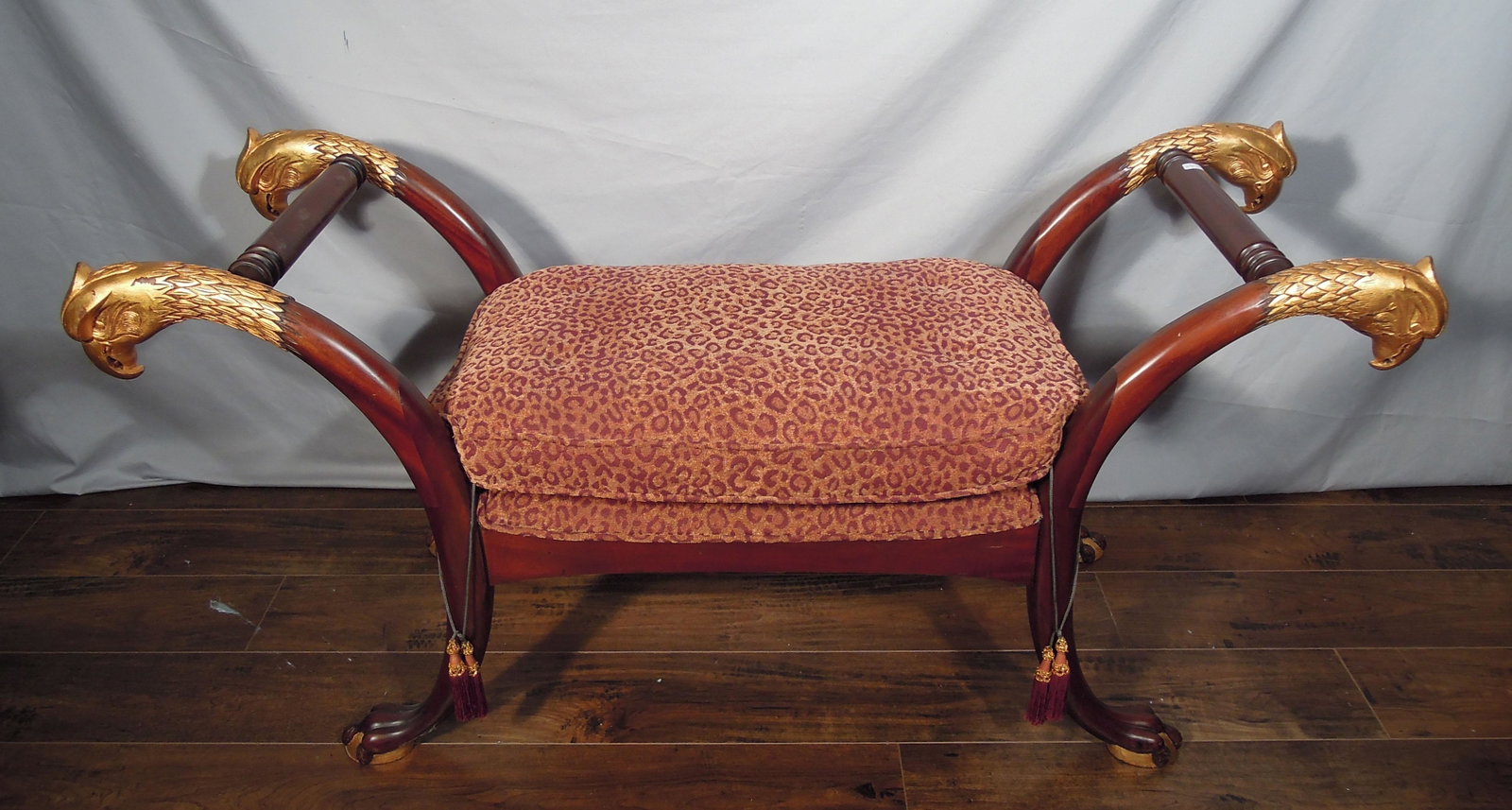 HAND CARVED WOODEN EAGLE BENCH: Upholstered becnh with eagle head arms and claw feet. 27" High, 53" Wide, 18" Deep.