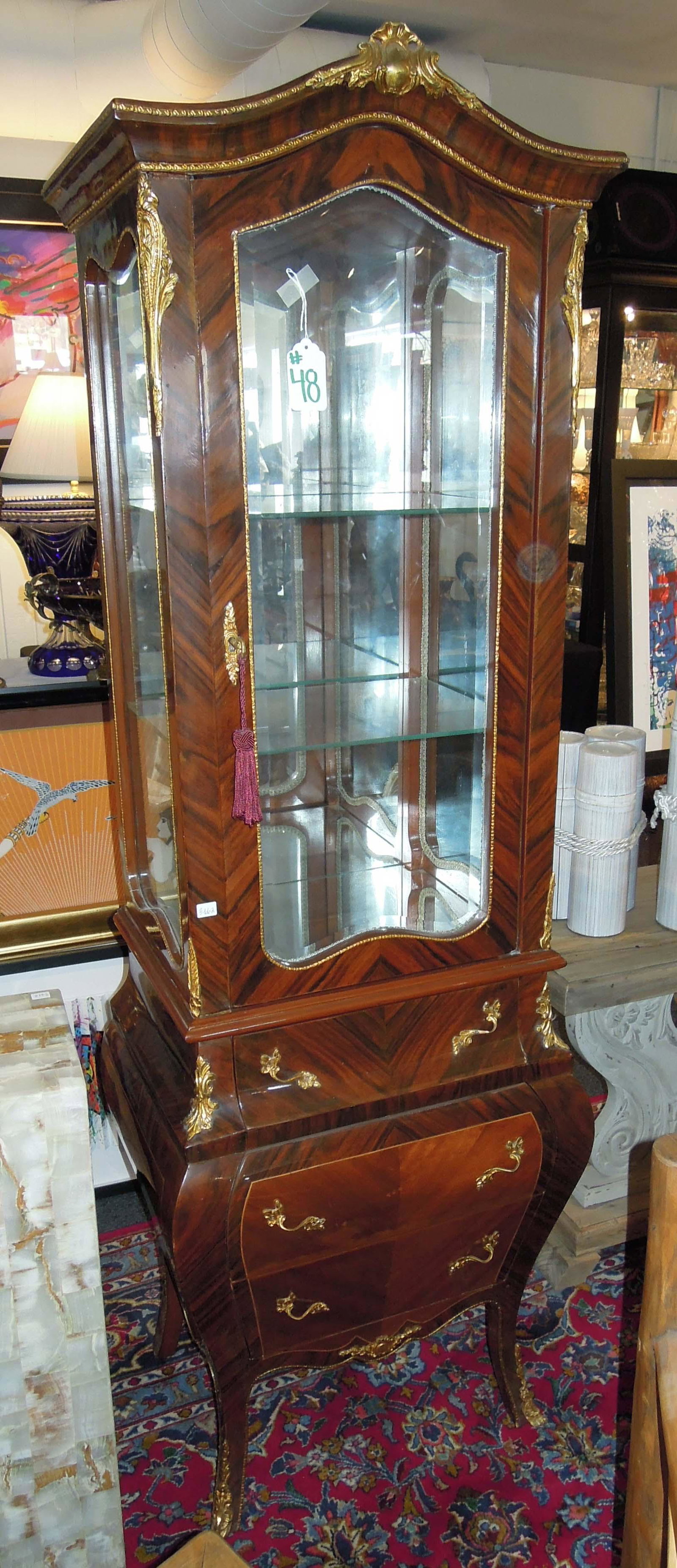 ITALIAN WOODEN CURIO WITH ORMOLU APPOINTMENTS: Lower portion with three drawers and upper portion with large single door which opens to reveal three glass shelves and mirrored back. 70" high, 23" wide, 17" deep.
