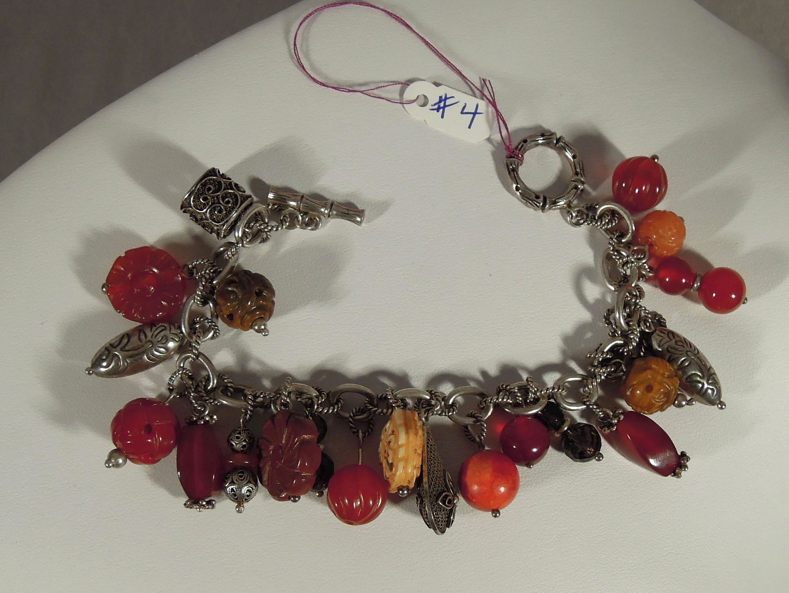 STERLING SILVER CHARM BRACELET: Charms include: Carnelian, tiger eye and sterling. 8" long.