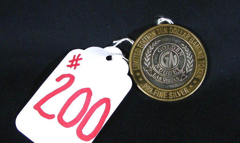 OLD SILVER GAMING TOKEN FROM THE GOLDEN NUGGET: OLD SILVER GAMING TOKEN FROM THE GOLDEN NUGGET Brass rim with a ½ oz. silver in center.