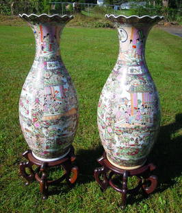 PAIR CHINESE PORCELAIN ROSE MEDALLION FLOOR VASES: Each vase with scalloped rim. Each decorated with figures and flowers. Each with rosewood stand. Vases 36 1/2" high, 47 1/2" high on rosewood stands.