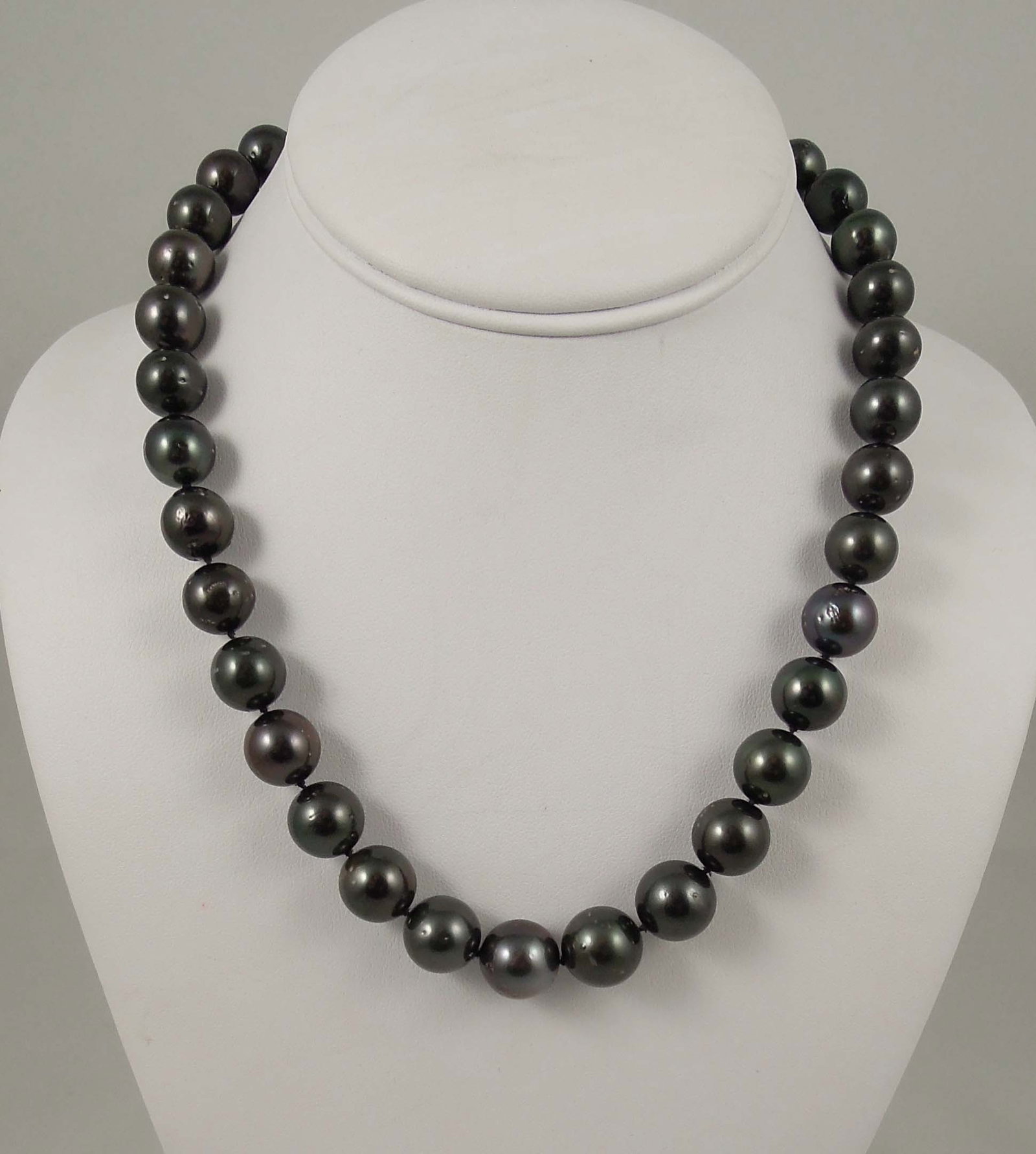 LADIES GRADUATED TAHITIAN BLACK SOUTH SEA PEARL NECKLACE: Pearls measure 11-14mm. 14K gold clasp. 18" long.