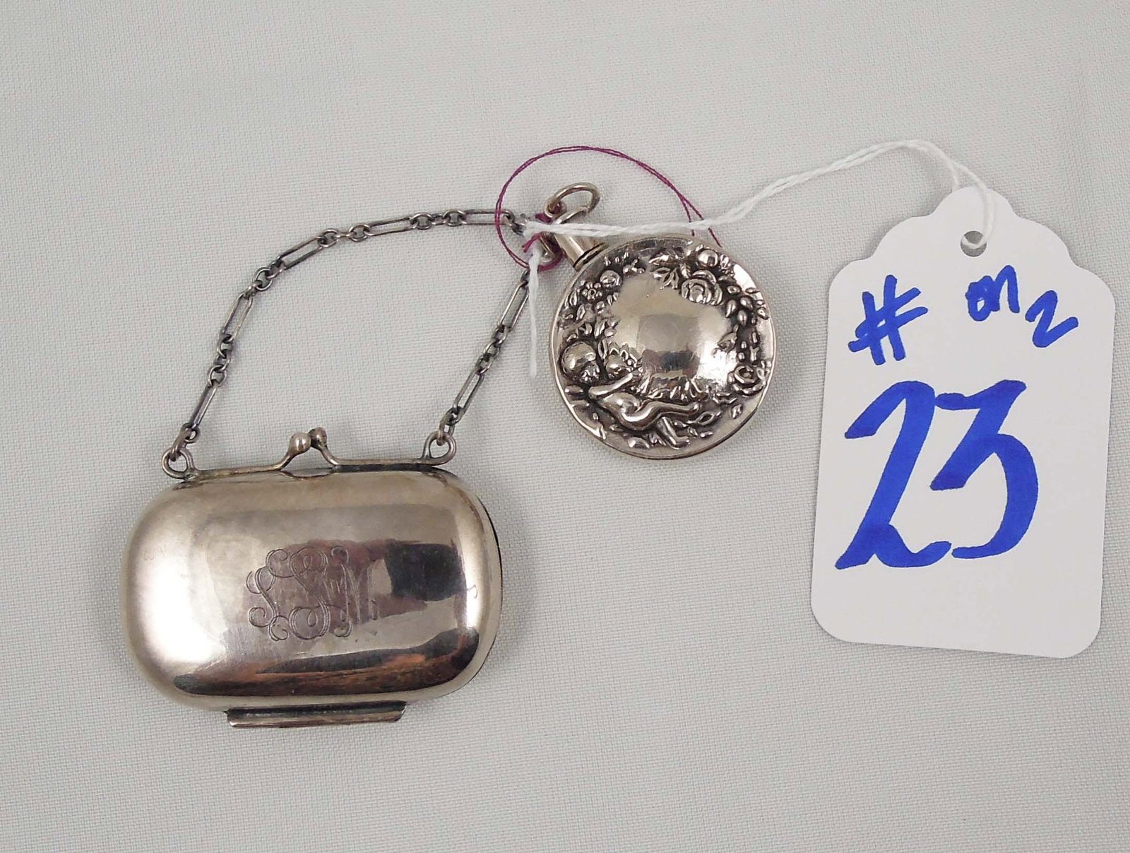 TWO STERLING SILVER ACCESSORIES: One purse shaped pill box and a mini perfume bottle.