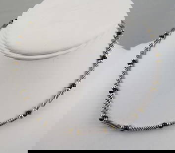 DESIGNER DAVID YURMAN 14K Y.G., STERLING & ONYX NECKLACE: A sterling cable necklace with yellow gold sections and onyx beads. Signed. 15 1/4" long.