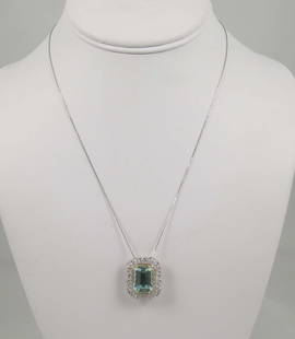 LADIES FINE 14K W.G., AQUAMARINE & DIAMOND NECKLACE: A white gold chain supports a beautiful pendant set with a center tapered fine aquamarine weighing 7.78 cts. Aquamareine is surrounded by a spray of full cut round diamonds totaling .51 ct.