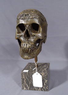 HEAVY BRONZE SCULPTURE OF SKULL ON MARBLE BASE: Ornate decorations in high relief on skull. 14" high.