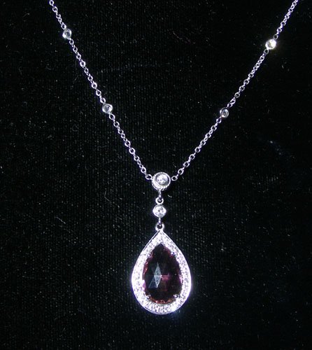 LADIES 18K WHITE GOLD, PINK TOURMALINE AND DIAMOND: LADIES 18K WHITE GOLD, PINK TOURMALINE AND DIAMOND NECKLACE A "Diamonds by the Yard" necklace supports a tear drop pendant set with a heavily faceted pink tourmaline weighing 2.70 cts. Tourmaline is s