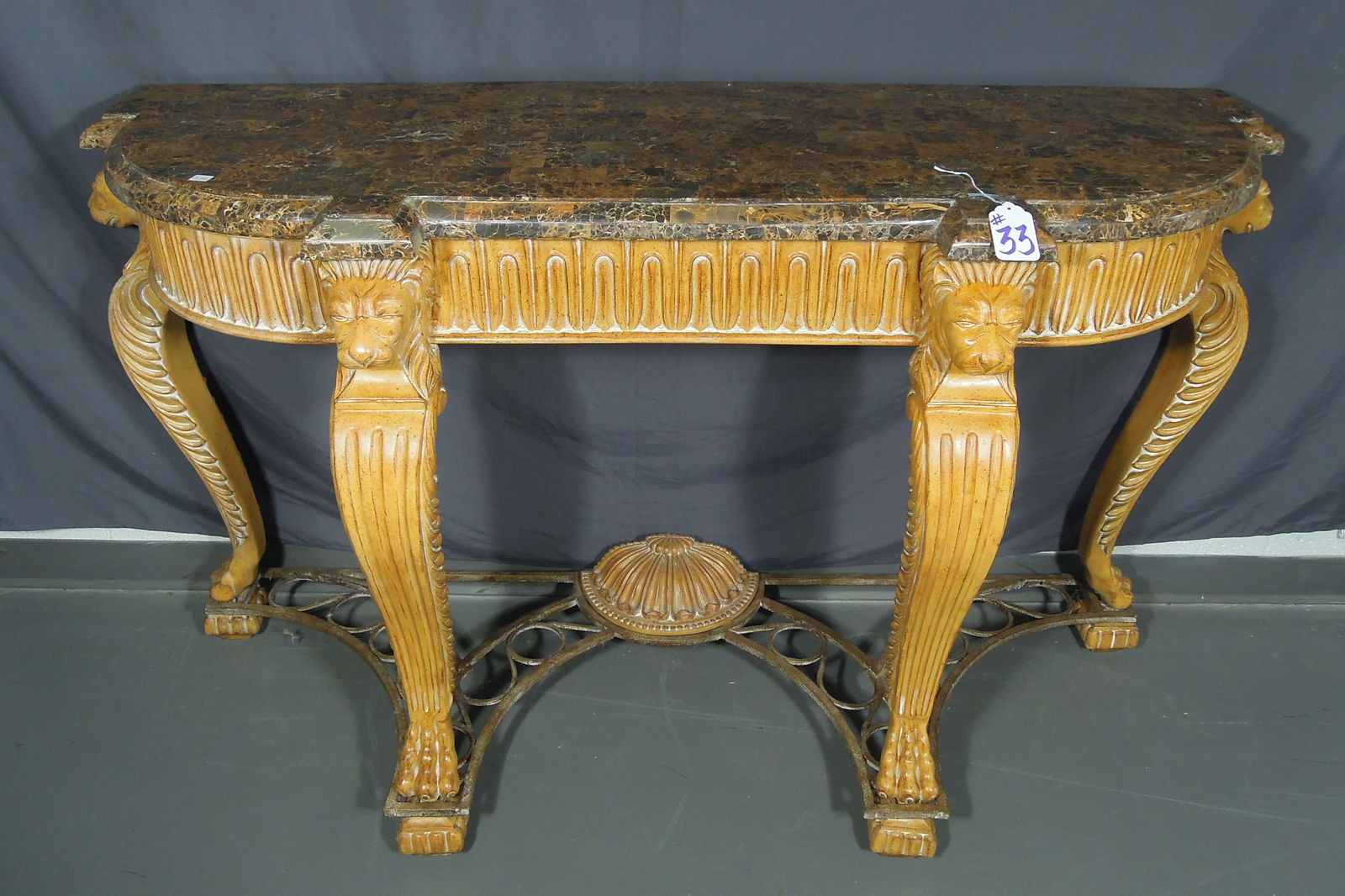 FINE HAND CARVED FAUX MARBLE TOP DEMI LUNE CONSOLE TABLE: Lion's head motif with claw feet. Cast iron metal base. 36" high, 62" wide, 22 1/2" deep.