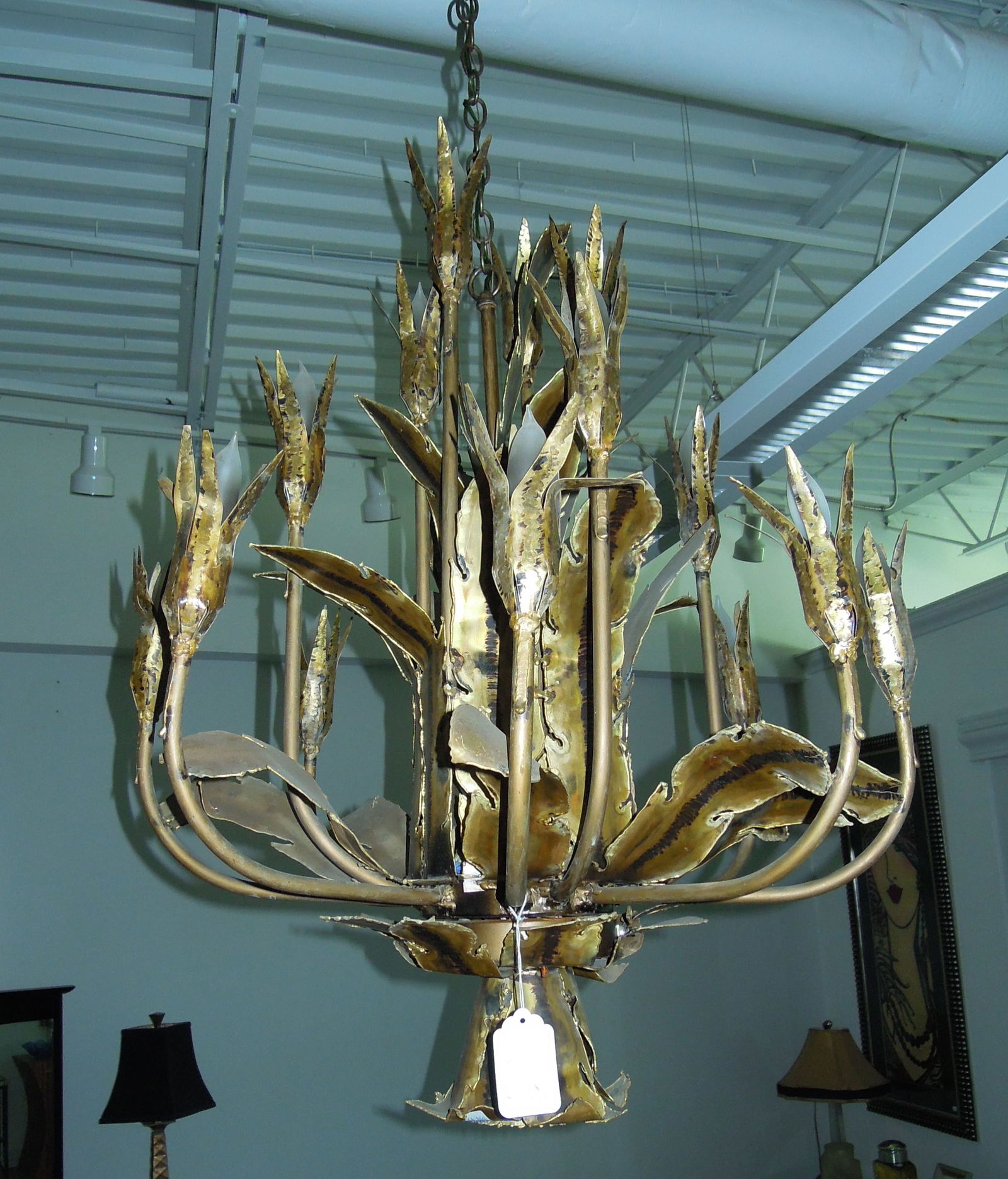 ORIGINAL TOM GREENE BRUTALIST CHANDELIER WITH HAND TORCHED PATINA.: Brass elements throughout. Sixteen arms with floral decorations. Circa 1950's-60's. 36" high, 28" dia.