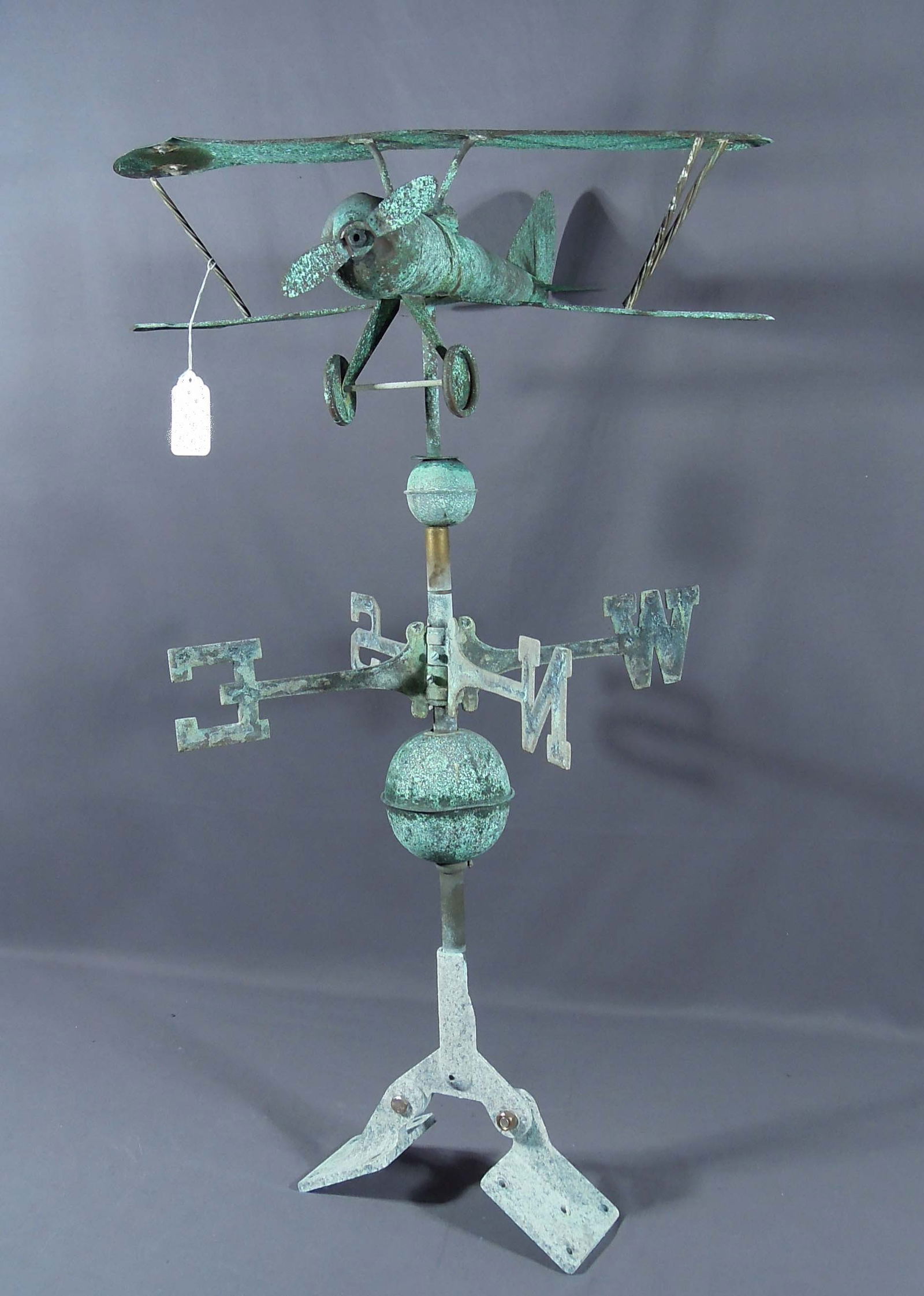 ANTIQUE COPPER BIPLANE WEATHER VANE: Heavy oxidation. Vintage condition. Directional and angle roof mount. 24 1/2" high, 24" long, 21 1/2" deep.