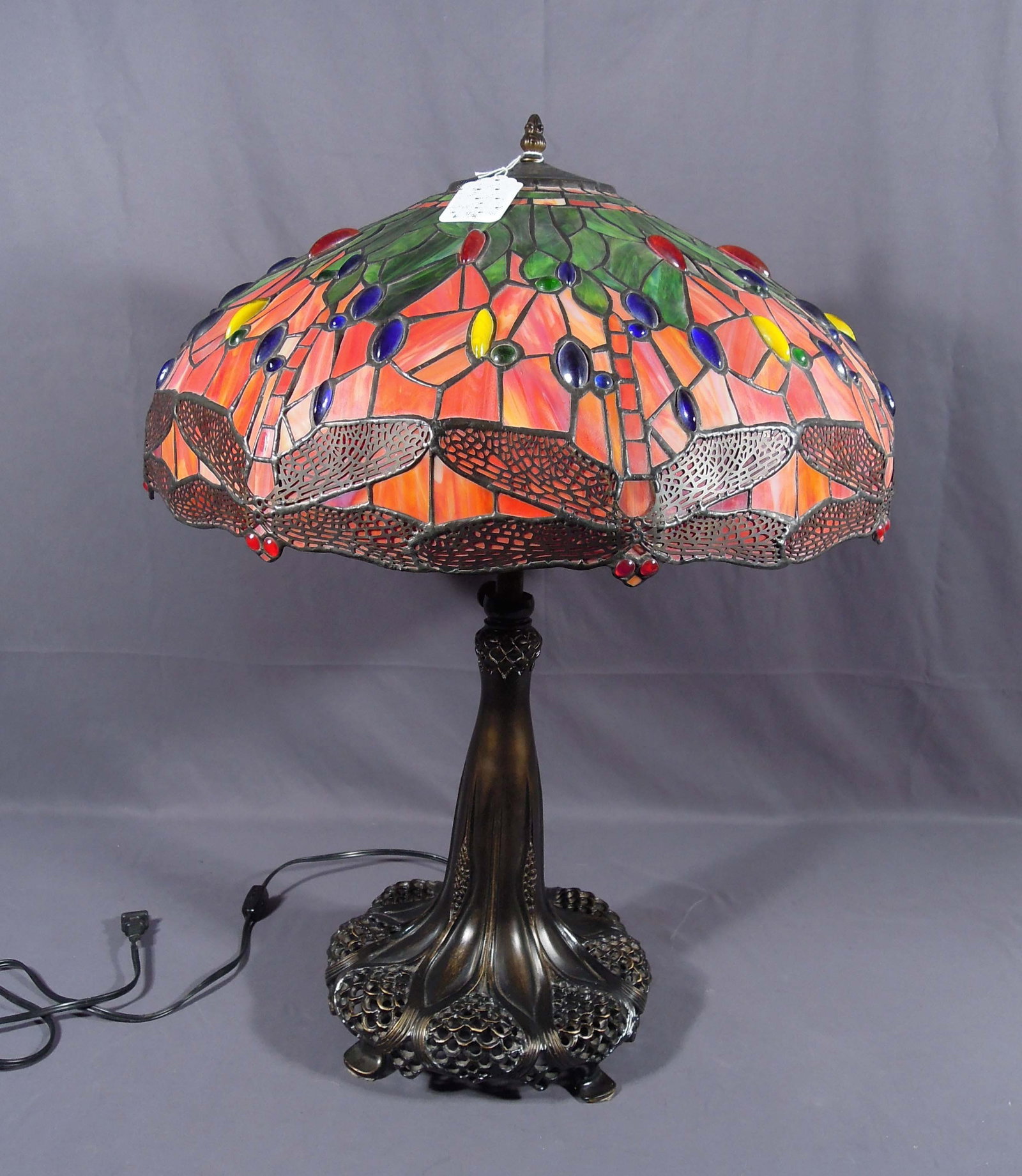 BRONZE AND LEADED GLASS DRAGONFLY TABLE LAMP: An ornate bronze base supports a domed leaded glass dragonfly shade. 28" high, 21" dia.