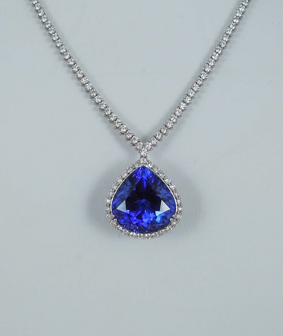 FABULOUS LADIES PLATINUM, TANZANITE AND DIAMOND NECKLACE: A platinum diamond set eternity necklace supports a pendant with a GIA certified pear shaped tanzanite weighing 20.81 cts. Intense violetish blue colorations with excellent symmetry. Tanzanite surroun