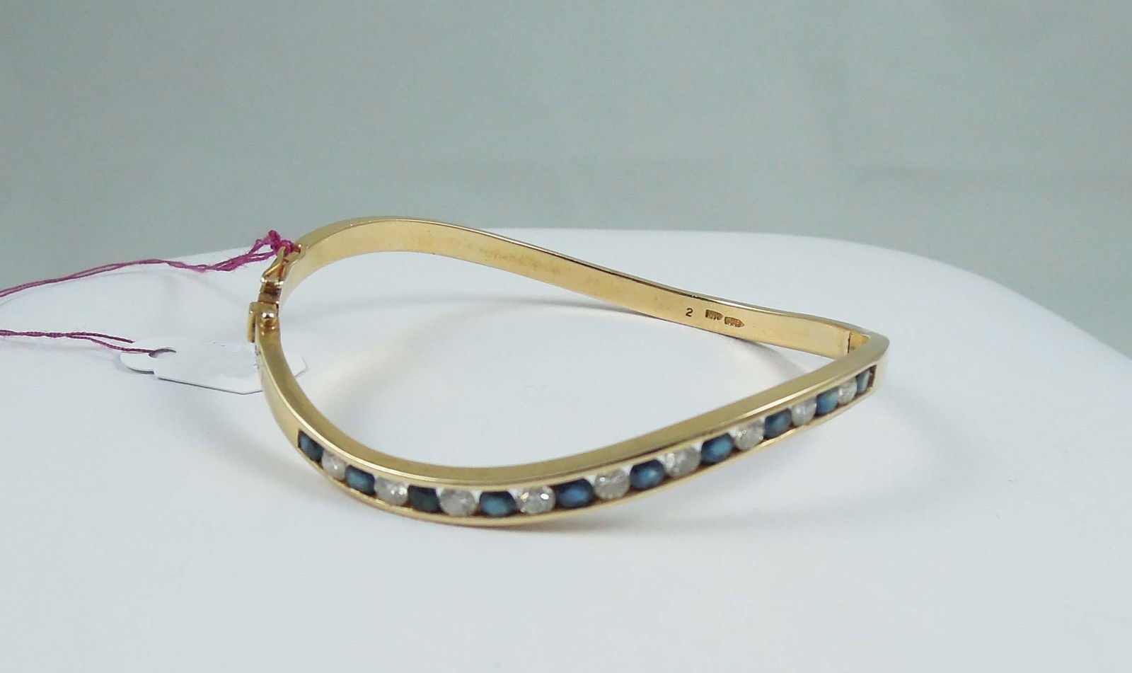 LADIES BEAUTIFUL 14K Y.G., SAPPHIRE & DIAMOND BANGLE BRACELET: A curved yellow gold bracelet set with a single row of alternating round sapphires and full cut round diamonds. Total gem weight approx. 1 ct. Bracelelt weighs 13.2 grams.