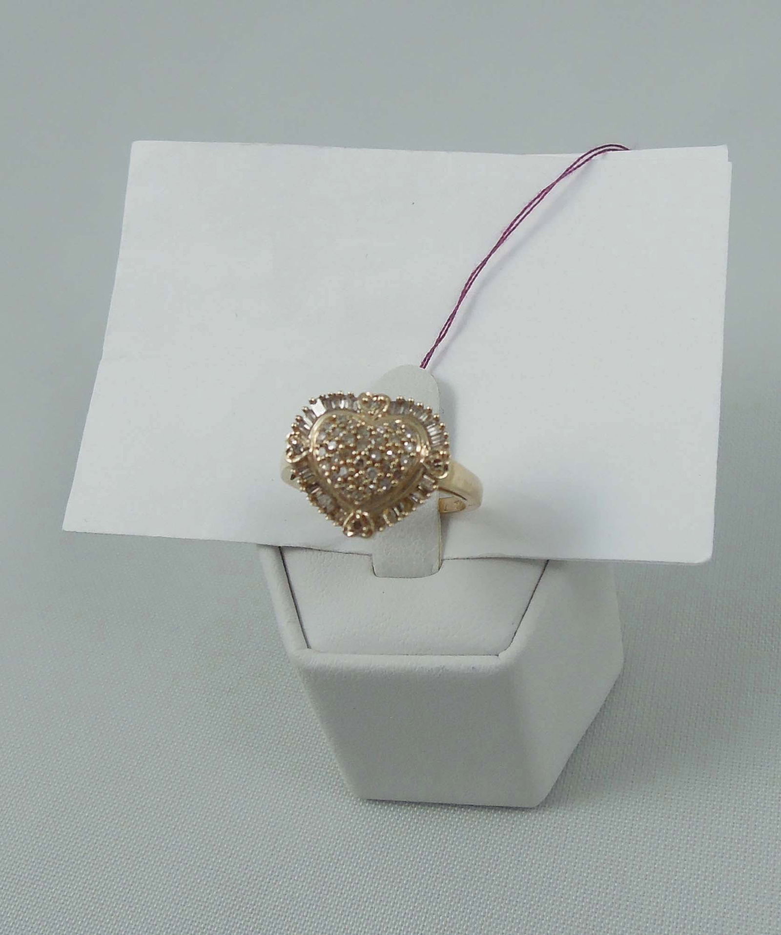 LADIES 10K Y.G. & DIAMOND HEART SHAPED RING: A highly polished mount with a center heart shaped section set with full cut round and baguette cut diamonds totaling approx. .50 ct.