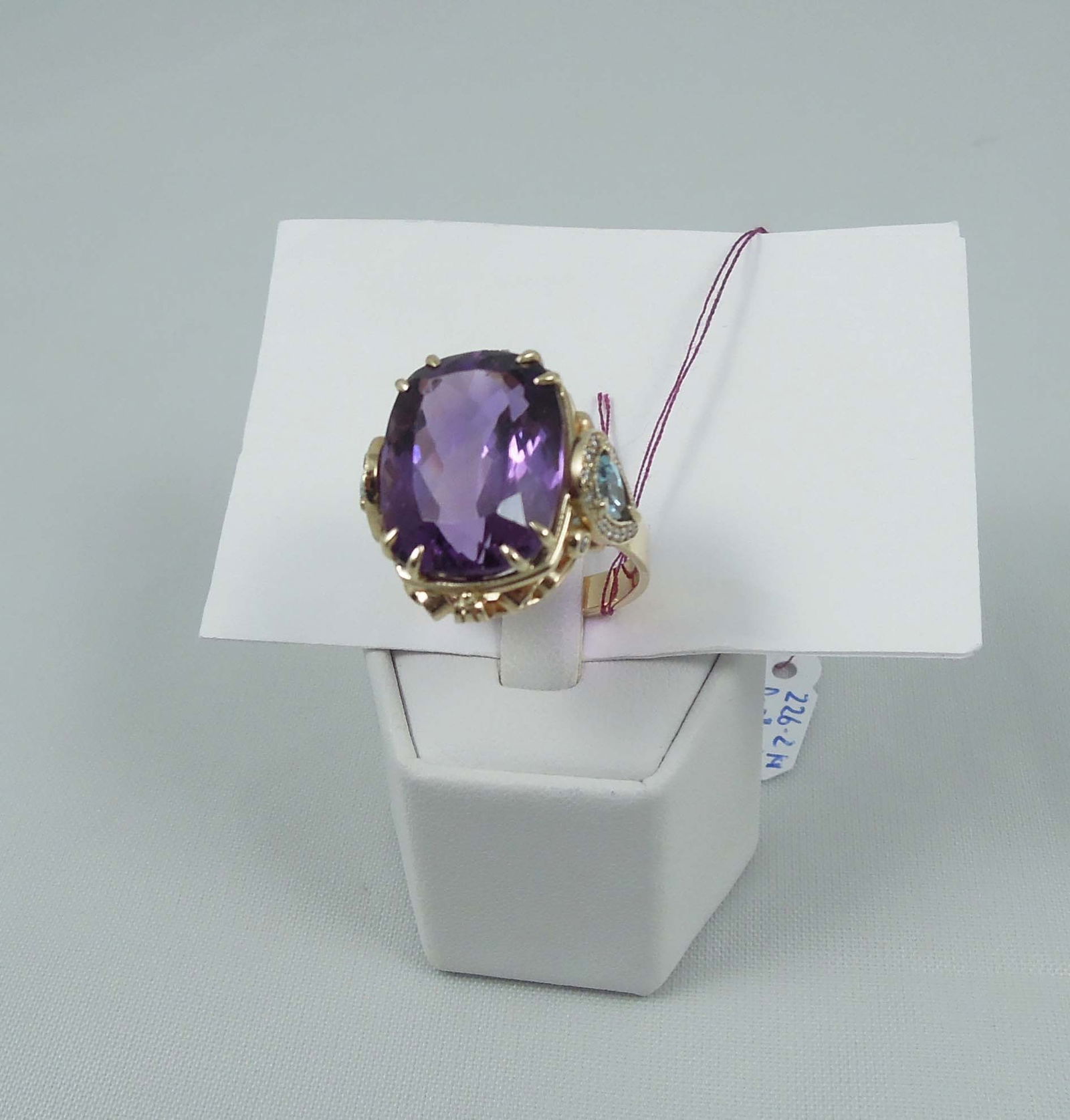 LADIES CUSTOM MADE 14K Y.G., AMETHYST, BLUE TOPAZ & DIAMOND RING: A very ornate yellow gold mount supports a large heavily faceted fine amethyst weighing approx. 15 cts. Amethyst flanked with two fine pear shaped blue topaz totaling approx. 2 cts. Ring garnished
