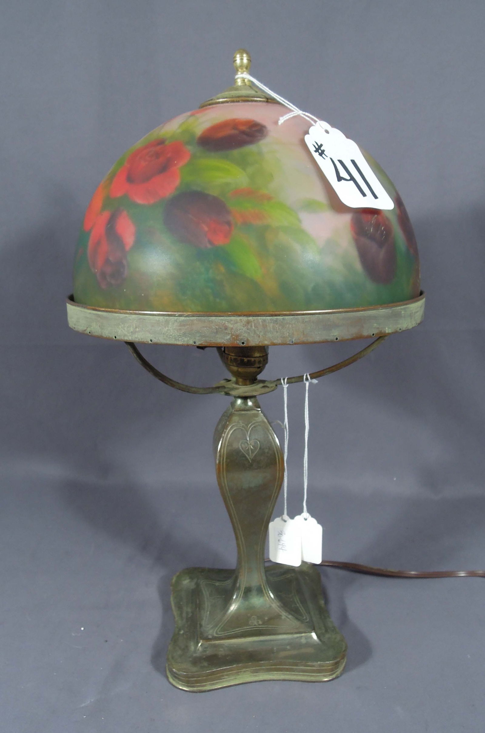 VINTAGE REVERSE PAINTED PAIRPOINT TABLE LAMP: An ornate signed Pairpoint base supports a domed reverse painted rose garden shade. Shade unsigned. 18" high, 9 3/4" dia.